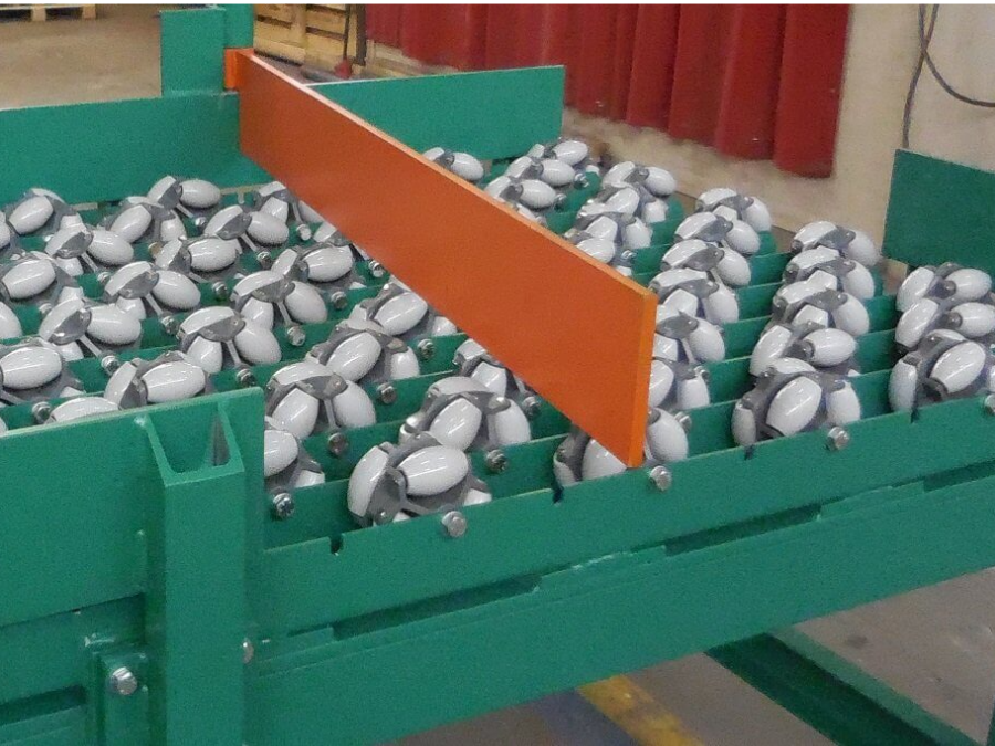 Rulli metallici industriali su trasportatore verde